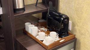a coffee maker and cups on a wooden shelf at Vendi Grand Square Residence in Sibiu