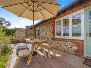 a picnic table and an umbrella on a patio at Swallow - Uk50155 in Faversham