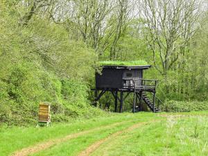 a small building with grass on it next to a dirt road at Swallow - Uk50155 in Faversham +17 photos