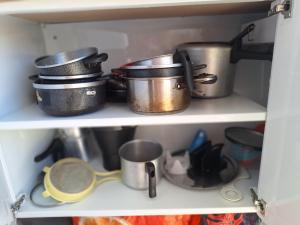 a shelf with pots and pans and other kitchen utensils at Silsol in Itacaré +7 photos
