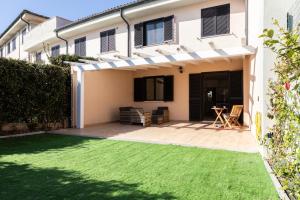 eine Terrasse mit Rasen vor einem Haus in der Unterkunft Green Lodge in Marco Simone