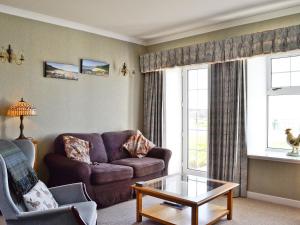 a living room with a couch and a coffee table at Belloch Cottage in Glenbarr