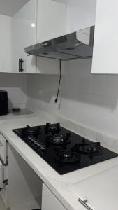 a black stove top in a white kitchen at Casa Nury in Santo Domingo