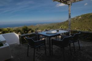 a table and chairs on a patio with a view at Blue & Earth Kea in Ioulis