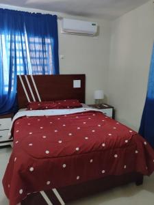 a bedroom with a red bed with white polka dots at Casa Nury in Santo Domingo +2 photos