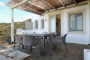 a patio with a table and chairs on a balcony at Blue & Earth Kea in Ioulis