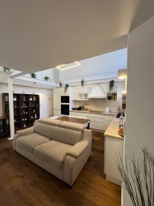 a large living room with a couch and a kitchen at DEA DREAMS - Lofty Marghera in Milan