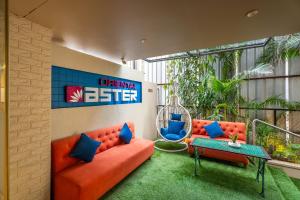 eine Wohnungsterrasse mit orangefarbenen Möbeln und blauen Kissen in der Unterkunft Hotel Oriental Aster - Mumbai International Airport in Mumbai + 49 Fotos