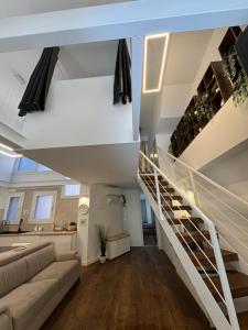 a living room with a staircase and a couch at DEA DREAMS - Lofty Marghera in Milan