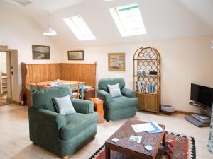 a living room with two chairs and a table at Coachman's Bothy - Ukc5958 in Port Appin