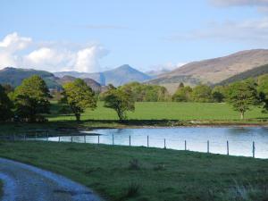 a river in a field with mountains in the background at Coachman's Bothy - Ukc5958 in Port Appin