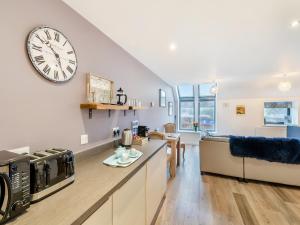 a kitchen and living room with a clock on the wall at Gracie's in Alnwick