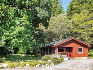a small red cabin in the middle of a forest at Ard Darach Lodge in Dunoon