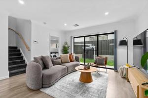 a living room with a couch and a table at Steps to the Beach Cafes moderm stylish 3BR in Christies Beach