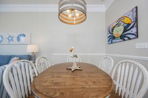 a dining room with a wooden table and chairs at Phoenix VI 6104 in Orange Beach