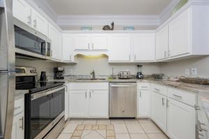 a white kitchen with white cabinets and appliances at Phoenix VI 6104 in Orange Beach