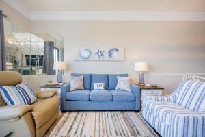 a living room with a blue couch and a chair at Phoenix VI 6104 in Orange Beach