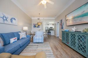 a living room with a blue couch and a table at Phoenix VI 6104 in Orange Beach