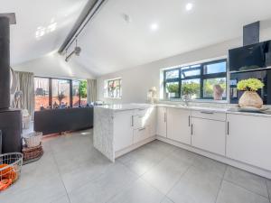 a kitchen with white cabinets and a large window at Lower Peastocking in Meriden
