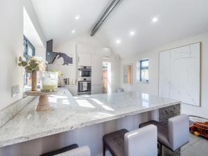 a kitchen with a large marble counter and chairs at Lower Peastocking in Meriden