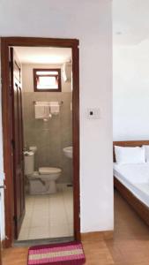 a bathroom with a shower and a toilet and a bed at Motel Minh Thảo in Danang +49 photos