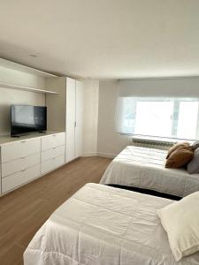 a bedroom with two beds and a flat screen tv at Apart Exclusivo a Estrenar - Tu Base Perfecta in El Calafate