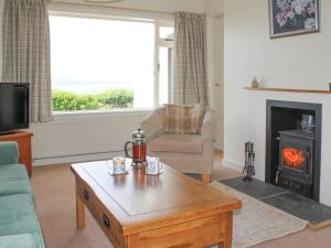 a living room with a coffee table and a fireplace at Aird House in Ardfern
