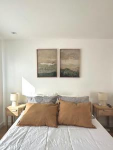 a bedroom with a bed with two paintings on the wall at Apart Exclusivo a Estrenar - Tu Base Perfecta in El Calafate +2 photos
