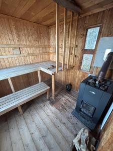an inside view of a sauna with a bench and a stove at Torpidyll nära sjö in Vetlanda +6 photos