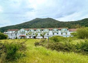 a large white building with a mountain in the background at Hostal de Berria in Santoña