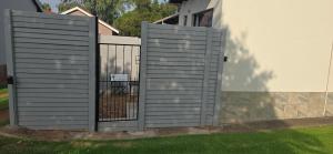 a fence with a gate in front of a house at Seek First B&B in Pretoria