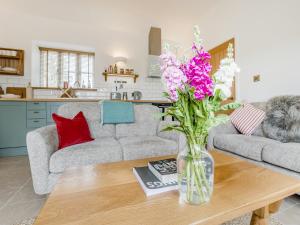 a vase of flowers on a coffee table in a living room at Wren - Uk50152 in Stalisfield