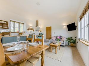 a kitchen and living room with a wooden dining table at Wren - Uk50152 in Stalisfield