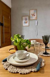 a table with a bowl and a plate on a table at Flat Aconchego no Setor Oeste a 50m do Lago das Rosas, apto novo in Goiânia