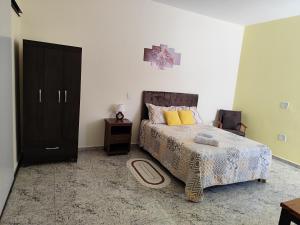 a bedroom with a bed and a black cabinet at Soninho Bão in Cunha