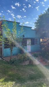 a blue house with a hose in front of it at Roberto in Posadas