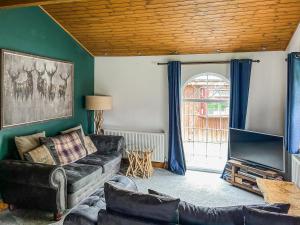 a living room with a couch and a tv at The Curious Stag in Rothbury