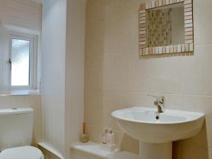 a bathroom with a sink and a toilet at Raglan Cottage in Ardentinny