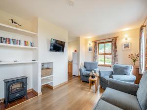 a living room with two chairs and a fireplace at Cruinn in Taynish
