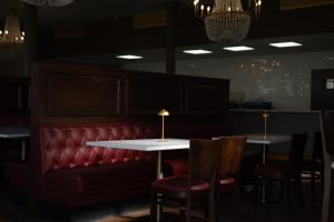 a restaurant with two tables and chairs and a red couch at The St Nicholas Hotel in Albany +3 photos