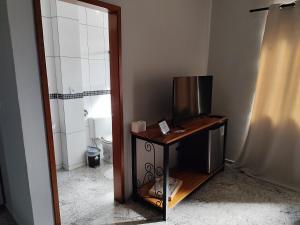 a bathroom with a table and a toilet and a mirror at Soninho Bão - Estilo 2 in Cunha
