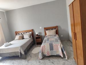 a bedroom with two beds and a night stand at Soninho Bão - Estilo 2 in Cunha