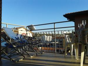 una terrazza con sedie e un parapetto con una barca di SWEET IRENE Deluxe a Bardolino