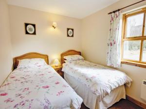 two beds in a small room with a window at Moy in Taynish