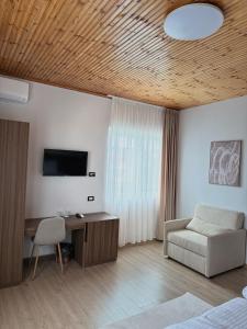 a bedroom with a desk and a tv and a chair at Hotel Aleks in Shkodër