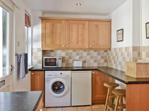 a kitchen with a washing machine and a microwave at Dunardry View in Lochgilphead