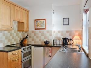 a kitchen with a sink and a stove top oven at Dunardry View in Lochgilphead