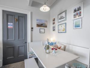 a room with a white table and a black door at Pier Haven - Cottage in Blairmore