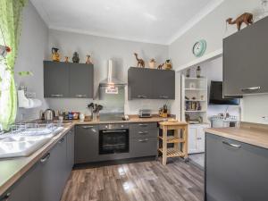 a kitchen with gray cabinets and a counter top at Pier Haven - Cottage in Blairmore +15 photos