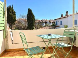 a table and two chairs on a balcony at Hotel Lou Marquès in Saintes-Maries-de-la-Mer